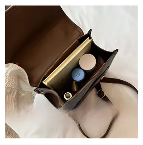 Interior view of brown leather backpack showing large storage space for tablet and cosmetics