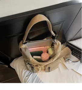 Vista dall'alto dell'interno spazioso della borsa a tracolla kaki con laptop e oggetti