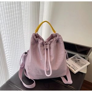 Dettaglio della borsa tote in nylon lavanda con manici gialli e chiusura a coulisse