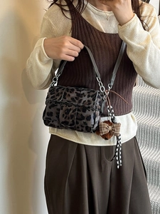 Crossbody bag with leopard print woven pattern, silver chain strap and bow charm
