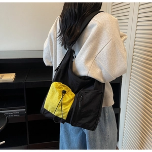 Dettaglio della borsa tote con tasca gialla a coulisse e trama in tessuto di nylon