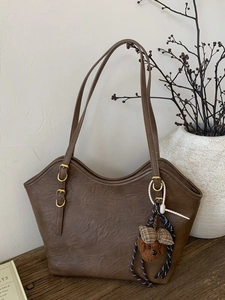 Braune Shopper-Tasche aus PU-Leder mit Bären-Anhänger in eleganter Retro-Atmosphäre