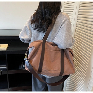 Detail of vintage brown canvas tote bag featuring durable straps and spacious side pocket