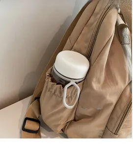 Detail of khaki nylon backpack side pocket with elastic drawstring for water bottles