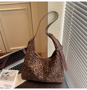 Detail of leopard print hobo bag with adjustable leather strap in a lifestyle setting