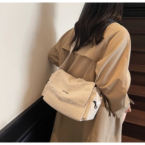 Detail of cream white pleated tote bag with flap and side zipper on a model