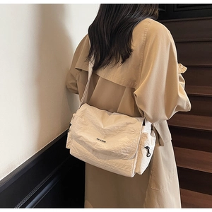 Detail of minimalist cream crossbody tote with wrinkled texture and YOU JI BEAR logo