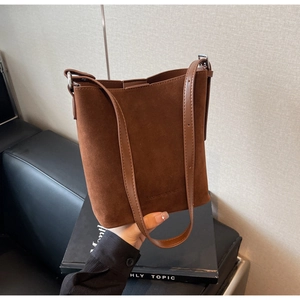 Detailed view of dark brown suede bucket bag featuring elegant Fashion & Bags embossing