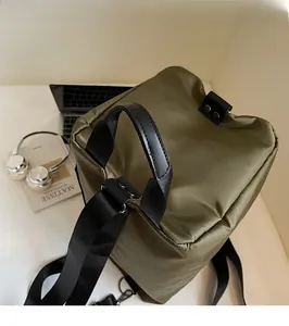 Detail of durable military green canvas backpack with sturdy handles and metal snap button
