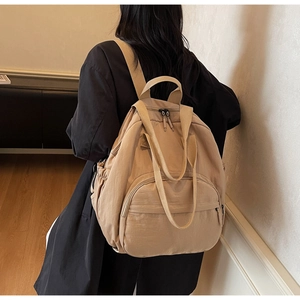 Detail of a khaki large-capacity nylon backpack showing its wrinkled texture and zipper pocket