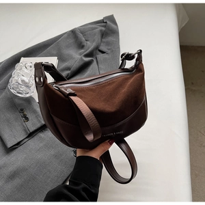 Detail of vintage brown suede and leather hobo bag with wide strap and fashion lettering