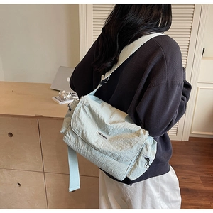 Detail of mint green nylon crossbody tote with adjustable strap and side zipper pocket