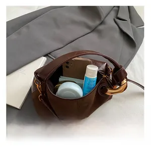 Detail show of large internal capacity for dark brown shoulder bag with metal rings