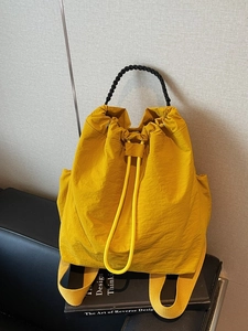 Zaino giallo con coulisse e manico intrecciato nero per uno stile urbano minimalista