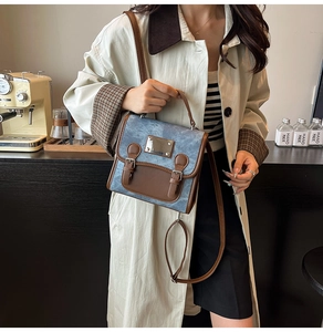 Detail of vintage denim and brown leather stitching on a stylish crossbody briefcase bag