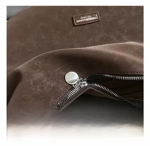 Close-up of vintage dark brown leather texture with silver zipper and circular puller