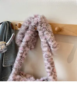 Detail of pink leopard faux fur tote bag hanging on wooden rack with cozy casual vibe