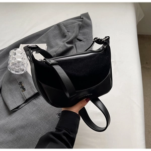 Detail of black patchwork shoulder bag with FASHION & BAGS print and silver zipper