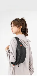 Detail der schwarzen Brusttasche mit Gittermuster, orangefarbenem Label und Gurt