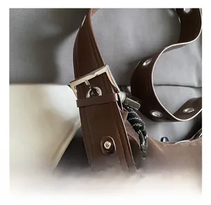 Detail view of the brown suede tote bag featuring an adjustable shoulder strap with silver buckle