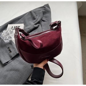 Detail of burgundy crescent saddle bag with matte finish and adjustable strap