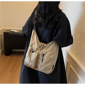 Vista laterale della borsa a tracolla casual con multitasche e base marrone