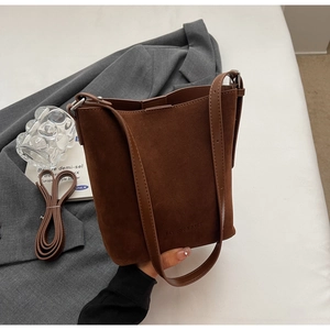 Detailed close-up of dark brown suede bucket bag with FASHION & BAGS embossed text