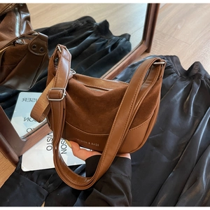 Detail of vintage brown saddle bag showing mixed smooth leather and matte suede textures