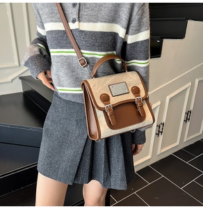 Close-up of vintage beige and brown patchwork leather messenger bag worn by model