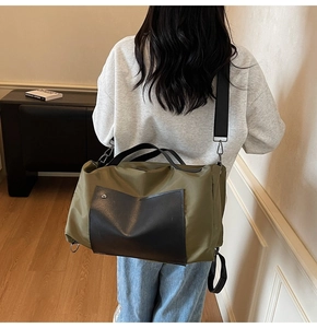 Detail of olive green travel bag showing waterproof nylon texture and leather accents