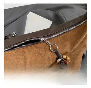 Close-up of vintage brown suede tote bag with smooth leather trim and beaded zipper puller