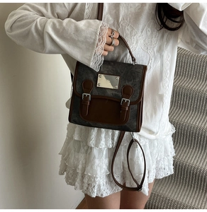 Close-up of vintage denim texture and metal buckle detail on retro women's satchel bag
