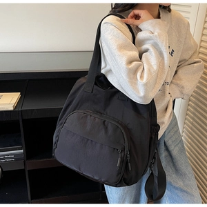 Detail of black nylon travel bag with large zipper pocket and elastic side pouch