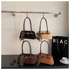 Detail of four matte suede vintage handbags in black, beige, brown, and caramel colors