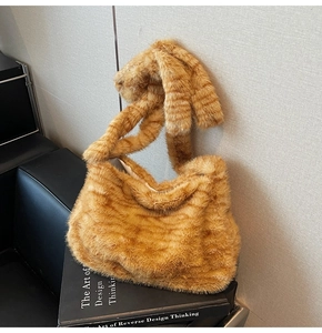Detail shot of plush faux fur tote bag with long bunny ears handles on a black chair