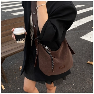 Detail of dark brown leather hobo bag with braided zipper and metal eyelet shoulder strap