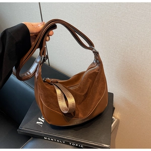 Detail of brown crescent saddle bag showing texture contrast between suede and smooth leather