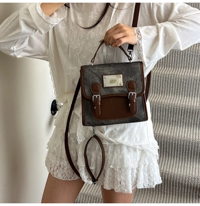 Detail shot of the vintage gray matte backpack with brown leather straps and metal hardware