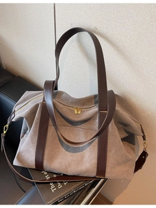 Large taupe canvas travel tote bag with brown leather straps and gold hardware