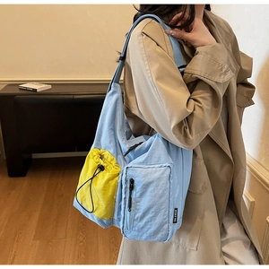 Dettaglio della borsa a tracolla blu con tasca esterna gialla con coulisse funzionale