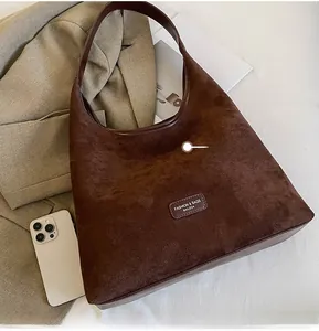 Size comparison of the large dark brown suede tote bag next to a mobile phone