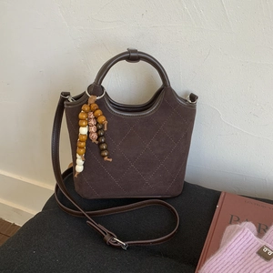 Sac seau en daim matelassé marron avec breloque en bois et bandoulière pratique