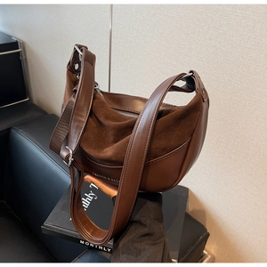 Detail of vintage dark brown suede and leather saddle bag with wide shoulder strap