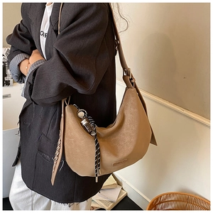Detail of khaki crescent hobo bag with adjustable strap and decorative braided lanyard