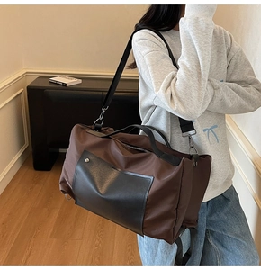 Detailed view of large travel bag featuring brown canvas and black PU pocket details
