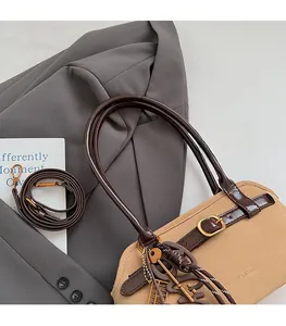Detail of khaki canvas tote with brown leather straps and gold abacus charm accessory