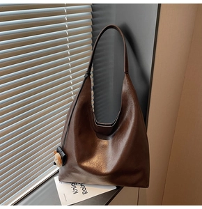 Detail view of vintage brown tote bag with textured faux leather and cute bear charm