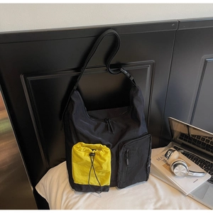 Dettaglio della grande borsa a tracolla in nylon con tasca gialla con coulisse e tracolla