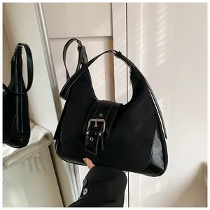 Detail der schwarzen Hobo-Tasche mit Kontrast aus mattem Wildleder und Lackleder