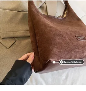 Close-up of brown suede tote bag featuring meticulous stitching and fashion brand label